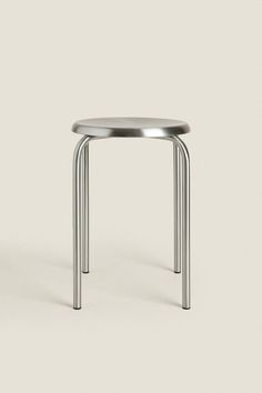 a small metal table with two legs on the top and one leg up against it