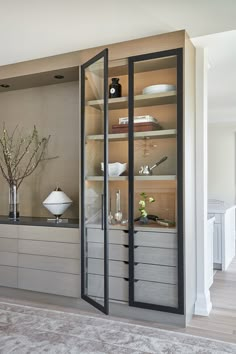 an open cabinet with glass doors in a living room