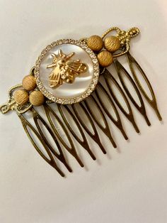 Honey Bee decorative hair comb. Hair comb of a unique character. So perfect for a romantic vintage look for a wedding or just to compliment your elegant style. All brass vintage parts. comb is metal for long wear. 1 -3/4 x 2- 1/2 inches.  Petite, a statement piece. Mother of pearl vintage button with crystal and golden bee Gorgeous! Holds hair well.  Love this beautiful unique creation. Thank You MyElegantThings Bee Hair Accessories, Decorative Hair Combs, Pearl Headpiece, Pearl Vintage, Comb Hair, Bridal Hair Comb, Hair Combs, Vintage Button, Look Vintage