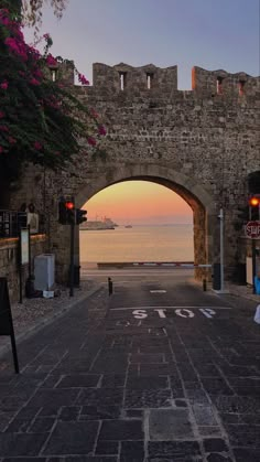 an archway leading into the ocean at sunset