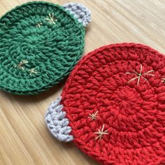 two crocheted christmas ornaments sitting on top of a wooden table next to each other