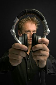 a man holding two headphones in front of his face