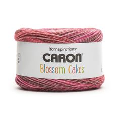 yarn that is pink and red with the words canon blossom cakes on it, in front of