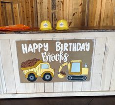 a birthday sign with construction vehicles painted on it