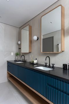 a bathroom with two sinks and mirrors on the wall