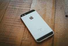 an iphone sitting on top of a wooden table