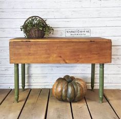 a wooden table with two metal pumpkins on it and a sign that says markethouse