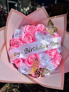 a bouquet of pink and white roses with a happy birthday message on it's ribbon