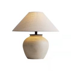 a table lamp with a white shade on it's base and a light bulb in the shape of a vase