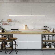 an industrial kitchen with white brick walls and wooden counter tops, two stools in front of the island