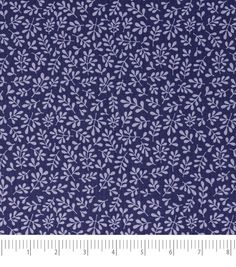 a blue fabric with white leaves on it and a ruler in front of the image