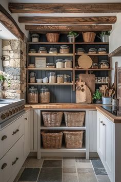 a kitchen filled with lots of baskets and cooking utensils on top of wooden shelves