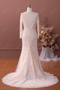 the back of a wedding dress on display in front of a mannequin head