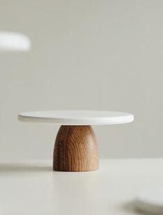 two white plates on top of each other with wood in the middle and one wooden object below