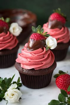 chocolate cupcakes with strawberry frosting and fresh strawberries on the top one