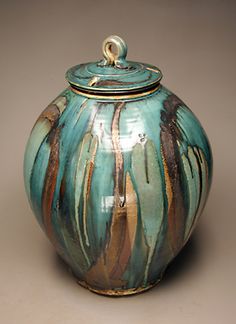 a blue and brown vase with a lid