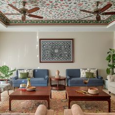 a living room with couches, chairs and tables in front of a painting on the wall