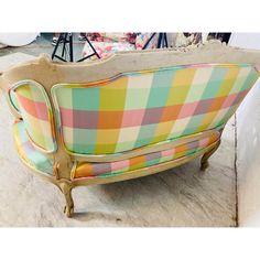 a colorful couch sitting on top of a floor next to a white table and chair