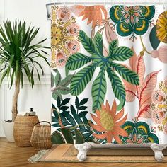 a shower curtain with colorful flowers and leaves on it next to a potted plant