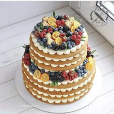 a three tiered cake with fresh fruit on top