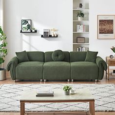 a living room with a green couch and coffee table in front of the bookshelf