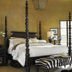 a bed room with a neatly made bed and zebra rug