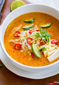 a white bowl filled with soup on top of a wooden table