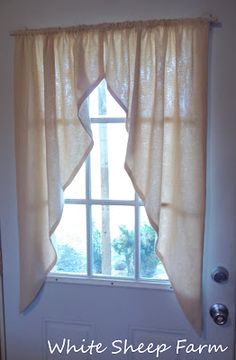 a white sheep farm window curtain in front of a door with the words white sheep farm written on it