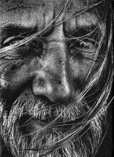 black and white photograph of an old man's face with hair blowing in the wind