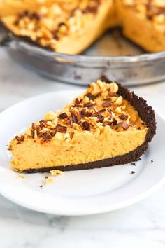 a slice of pumpkin pie on a plate with the rest of the pie in the background