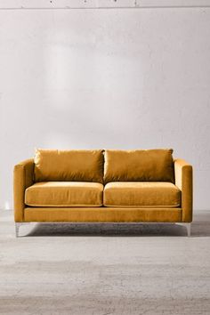 a yellow couch sitting in front of a white wall