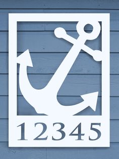 a white sign on the side of a blue building with an anchor and number below it