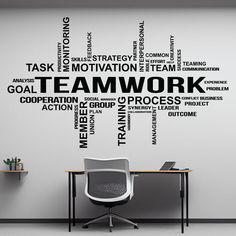 the word teamwork written in black on a white wall next to a desk and chair