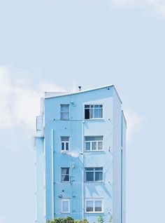 a blue building with trees in front of it