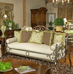 a living room filled with lots of furniture and green plants on top of the tables