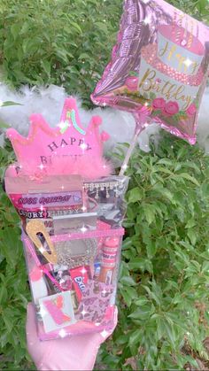 two pink princess themed birthday gifts in a basket on top of some bushes and trees