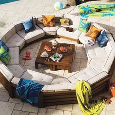 a circular couch sitting on top of a patio next to a swimming pool