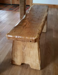 a wooden bench sitting on top of a hard wood floor