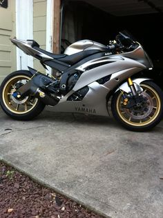 a silver motorcycle parked in front of a garage