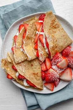 some pancakes and strawberries are on a plate