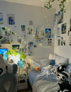 a bedroom with white walls and lots of pictures on the wall