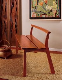 a wooden chair sitting on top of a rug in front of a wall mounted painting