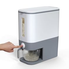 a hand is pressing the button on an automatic rice cooker that's attached to a wall