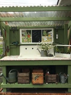 an outdoor kitchen made out of old pallets and other junks, with flowers in the window