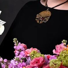 a woman wearing a black shirt holding flowers and an envelope with the word love written on it