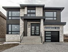 a large house with two garages and stone steps leading up to the front door