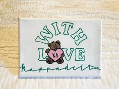 a patch with a teddy bear holding a heart in it's paws and the words, bite love hapquadiata