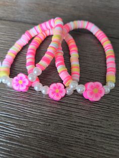 Bright pink, pastel pink, yellow, and white with a super cute pink hibiscus charm. Perfect for a tropical summer vibe! Bracelets Preppy, Colorful Bead Bracelets, Rainbow Loom Bands, Clay Bead Necklace, Diy Beaded Rings, Homemade Bracelets