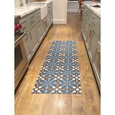 a kitchen with wooden floors and stainless steel appliances on the counter top, along with a blue tile floor