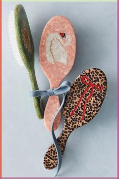 a pair of leopard print slippers next to a hair brush on a blue background